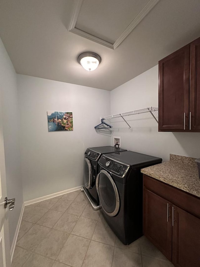 washroom featuring cabinets, ornamental molding, light tile patterned floors, and washing machine and clothes dryer