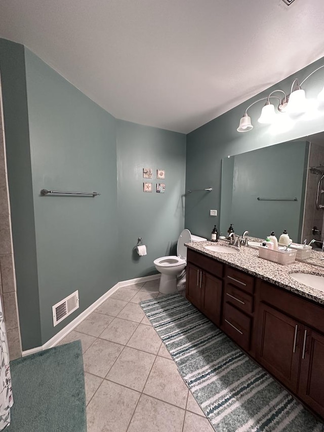 bathroom featuring vanity, a shower, tile patterned floors, and toilet