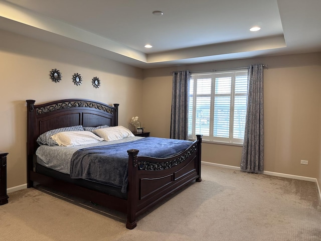 carpeted bedroom featuring a raised ceiling