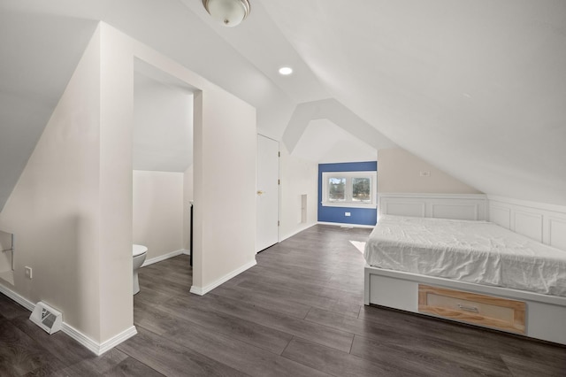 unfurnished bedroom with vaulted ceiling, dark wood-style floors, visible vents, and baseboards