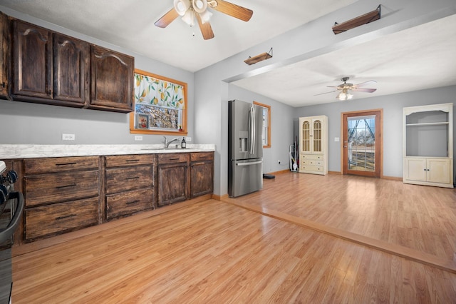 kitchen with dark brown cabinets, light wood finished floors, a ceiling fan, and stainless steel fridge with ice dispenser