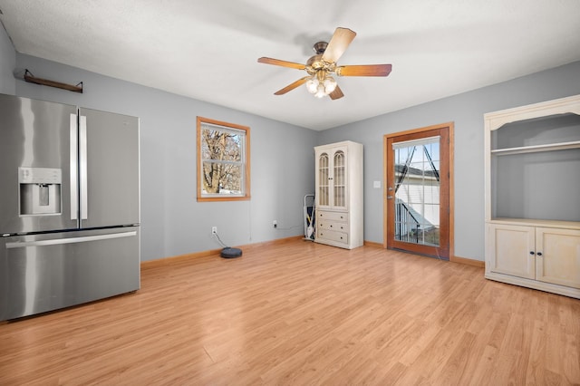 interior space featuring ceiling fan, baseboards, and wood finished floors