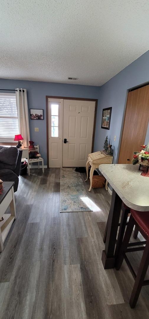 entrance foyer featuring dark wood-type flooring and a textured ceiling