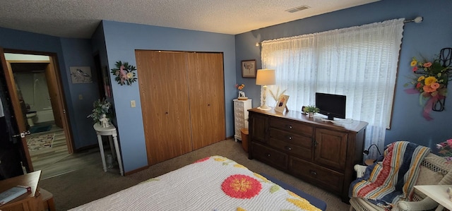 carpeted bedroom featuring a textured ceiling and a closet