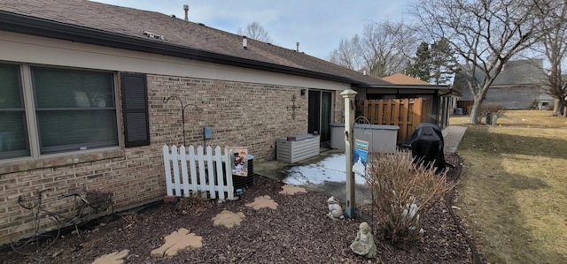 view of side of property with a patio and a lawn