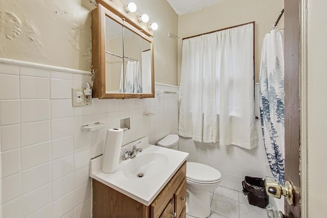 bathroom featuring vanity, toilet, and tile walls