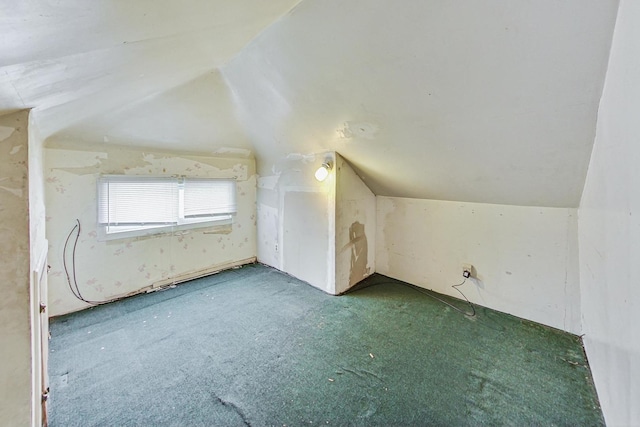 additional living space featuring vaulted ceiling and carpet flooring