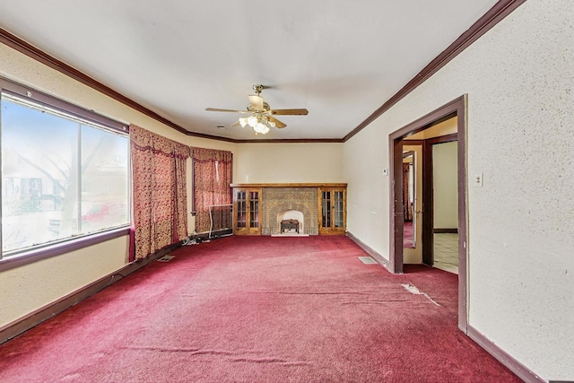 unfurnished living room featuring crown molding, carpet floors, a wealth of natural light, and ceiling fan