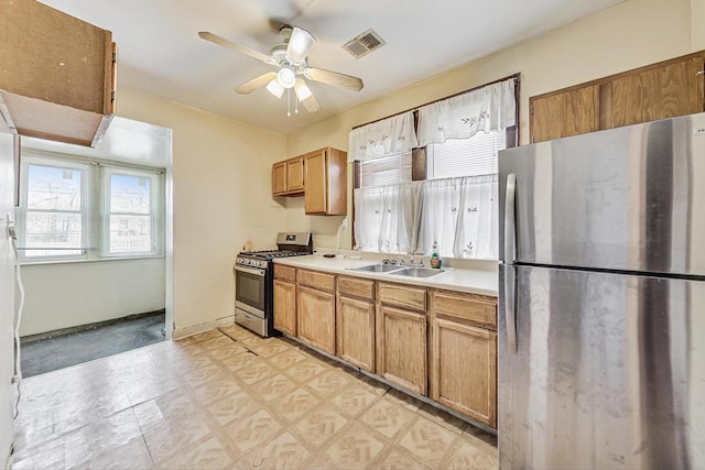 kitchen with appliances with stainless steel finishes, sink, and ceiling fan