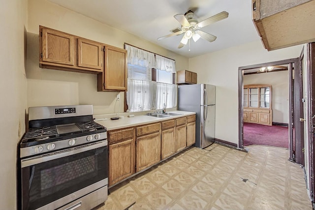 kitchen with a healthy amount of sunlight, appliances with stainless steel finishes, sink, and light colored carpet