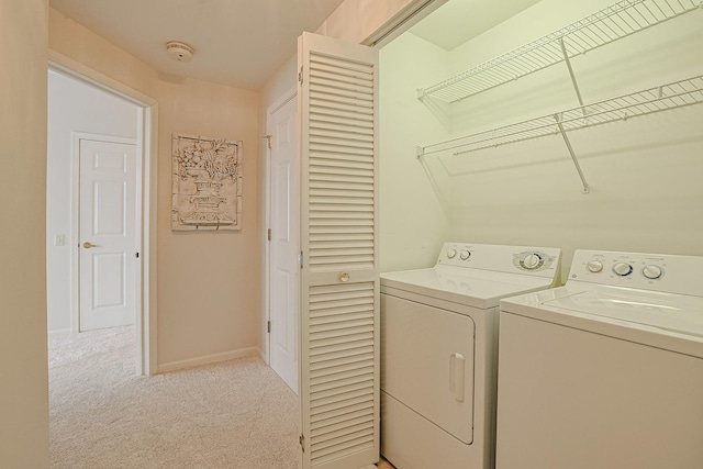 laundry room with separate washer and dryer and light colored carpet