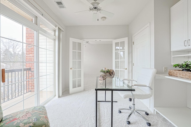 home office with light carpet, ceiling fan, and french doors