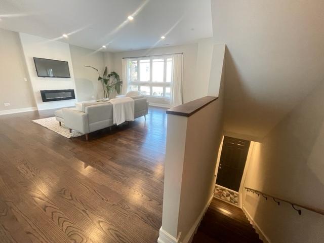 unfurnished living room with dark wood-type flooring