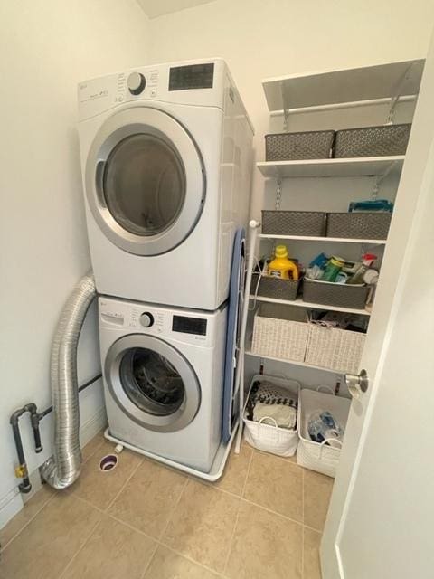 washroom with light tile patterned floors and stacked washer and clothes dryer