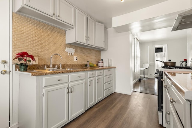 kitchen with sink, white cabinetry, backsplash, dark hardwood / wood-style floors, and range with gas cooktop