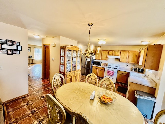 tiled dining space with an inviting chandelier and sink