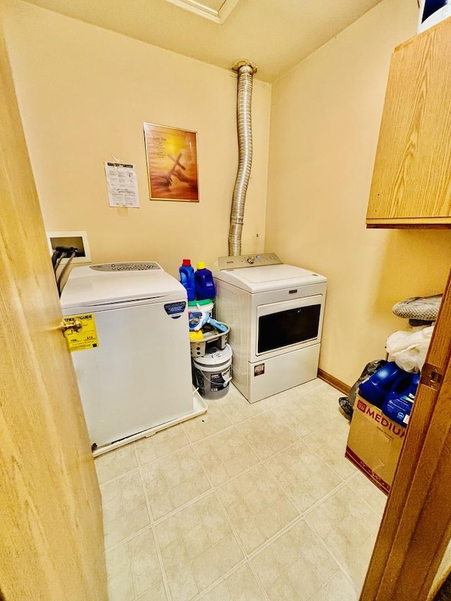 laundry room with cabinets and washer and clothes dryer