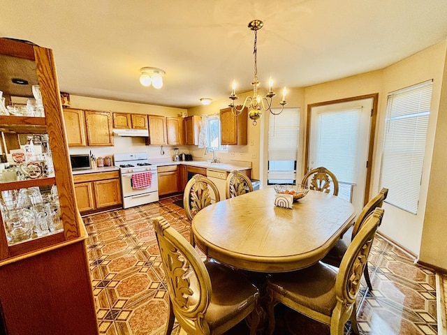 tiled dining area featuring sink and a notable chandelier