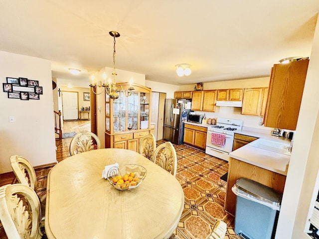 kitchen with an inviting chandelier, stainless steel appliances, and hanging light fixtures