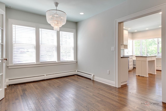 unfurnished dining area with dark wood-type flooring, a baseboard radiator, and a notable chandelier