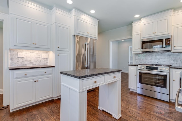 kitchen with white cabinetry, dark hardwood / wood-style flooring, a kitchen island, and appliances with stainless steel finishes