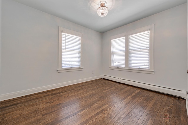 spare room with dark hardwood / wood-style floors and a baseboard heating unit