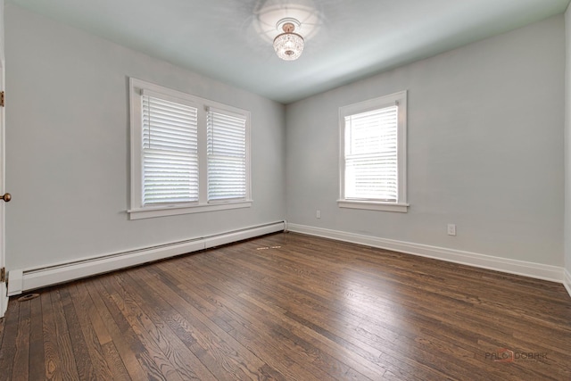 empty room with a baseboard radiator and dark hardwood / wood-style floors