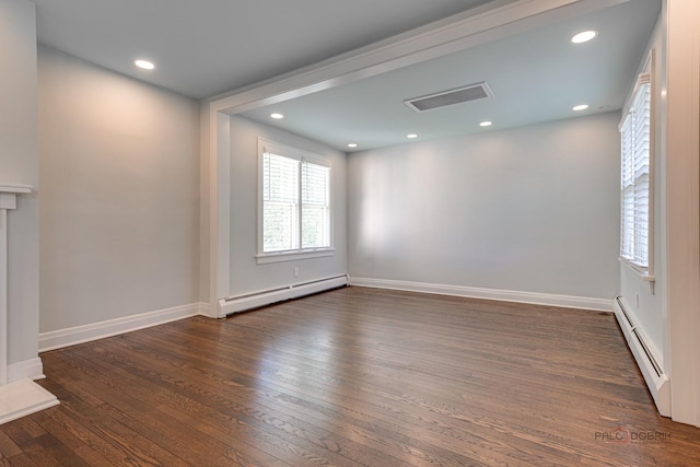 spare room featuring dark wood-type flooring and a baseboard radiator