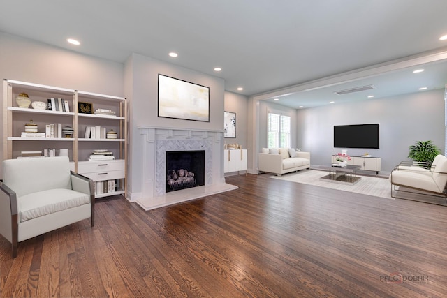 living room featuring dark wood-type flooring and a high end fireplace