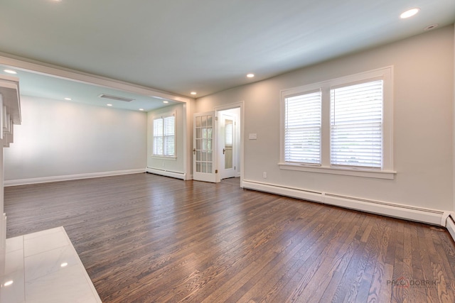 unfurnished room with a baseboard radiator and dark hardwood / wood-style floors