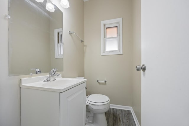 bathroom featuring vanity, wood-type flooring, and toilet