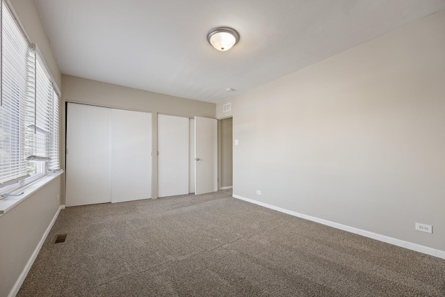 unfurnished bedroom featuring carpet floors and two closets