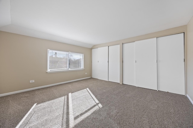 unfurnished bedroom with two closets and carpet