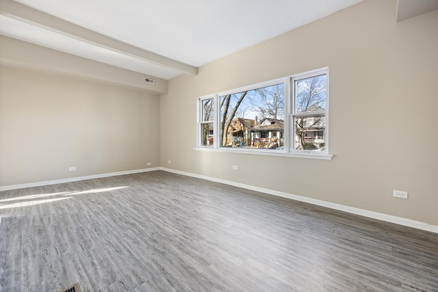 spare room with dark hardwood / wood-style floors and beam ceiling