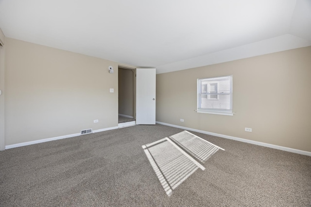 carpeted empty room with vaulted ceiling