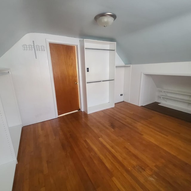 additional living space with wood-type flooring and vaulted ceiling