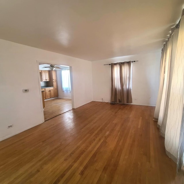 unfurnished living room featuring ceiling fan and hardwood / wood-style floors