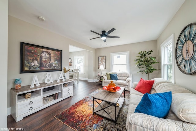 living room with dark wood-type flooring and ceiling fan