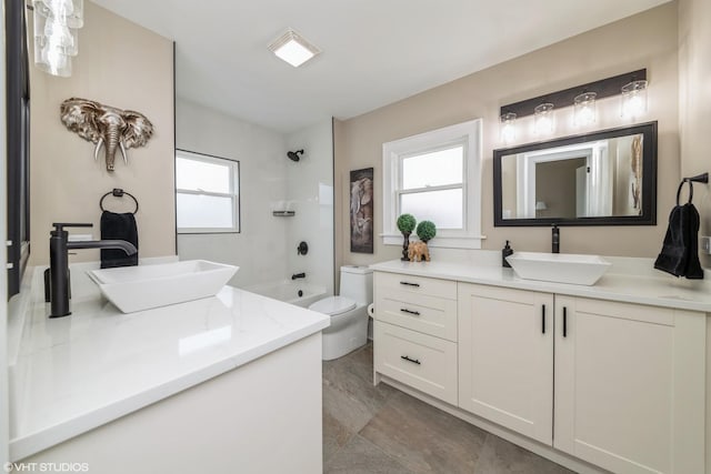 full bathroom featuring tiled shower / bath, vanity, and toilet