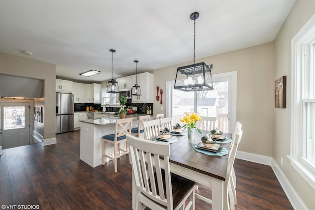 dining space with dark hardwood / wood-style floors and sink