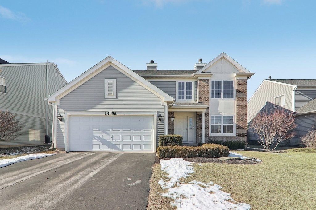 view of front property featuring a garage and a front lawn