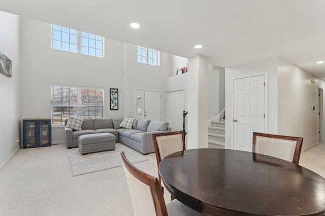 carpeted dining space featuring a high ceiling