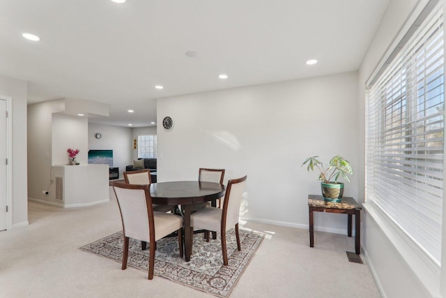 dining room with a wealth of natural light and light colored carpet