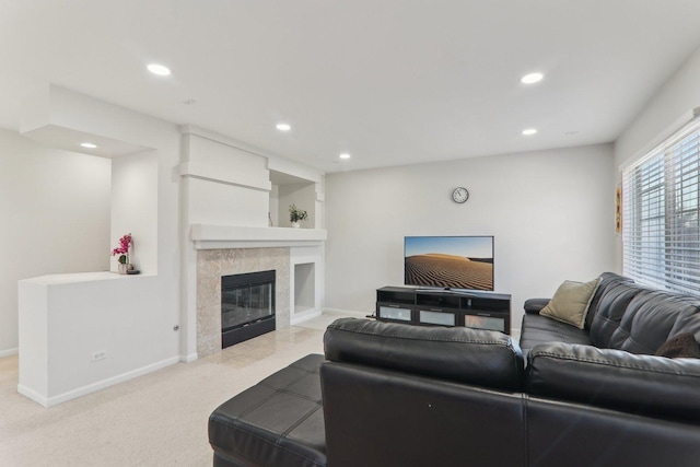 living room with a tiled fireplace and light carpet