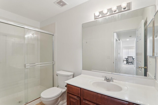 bathroom with vanity, toilet, and an enclosed shower