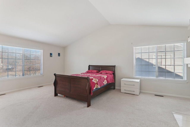 bedroom with multiple windows, lofted ceiling, and light carpet