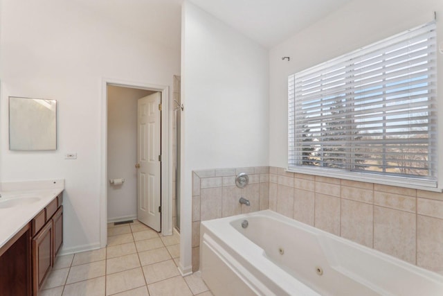 bathroom with tile patterned flooring, vanity, and a bath