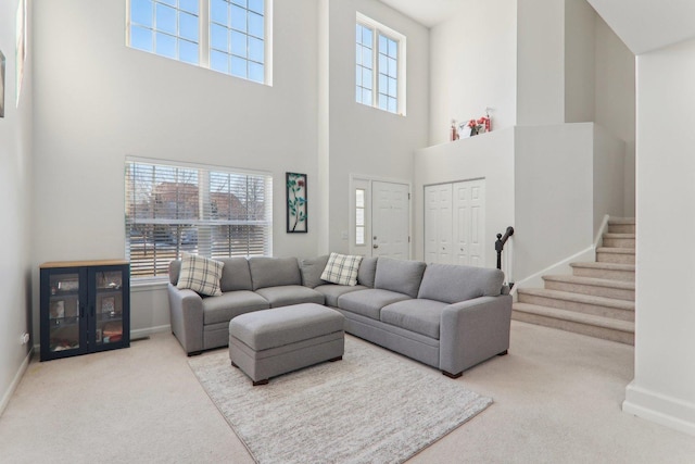 carpeted living room with a towering ceiling