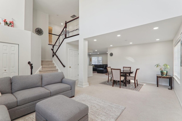 carpeted living room with a high ceiling