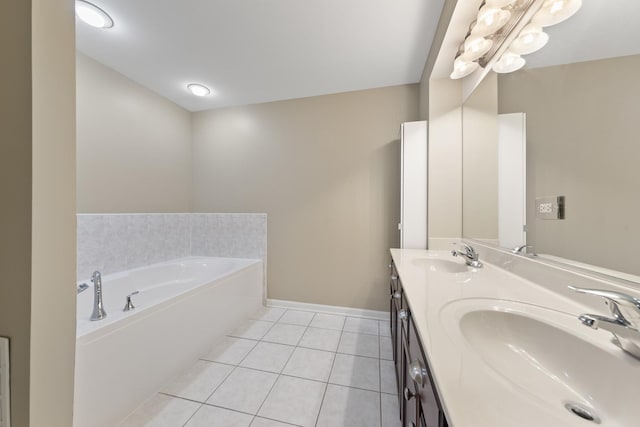 bathroom with tile patterned floors, a bath, and vanity